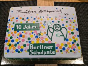 eine viereckige Torte mit dem Engel von Berliner Schulpate und Schriftzug "10 Jahre Berliner Schulpate"