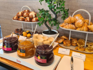 Ein Frühstücksbuffet mit Croissants, Marmeladen und kleinen Zimt-Schnecken